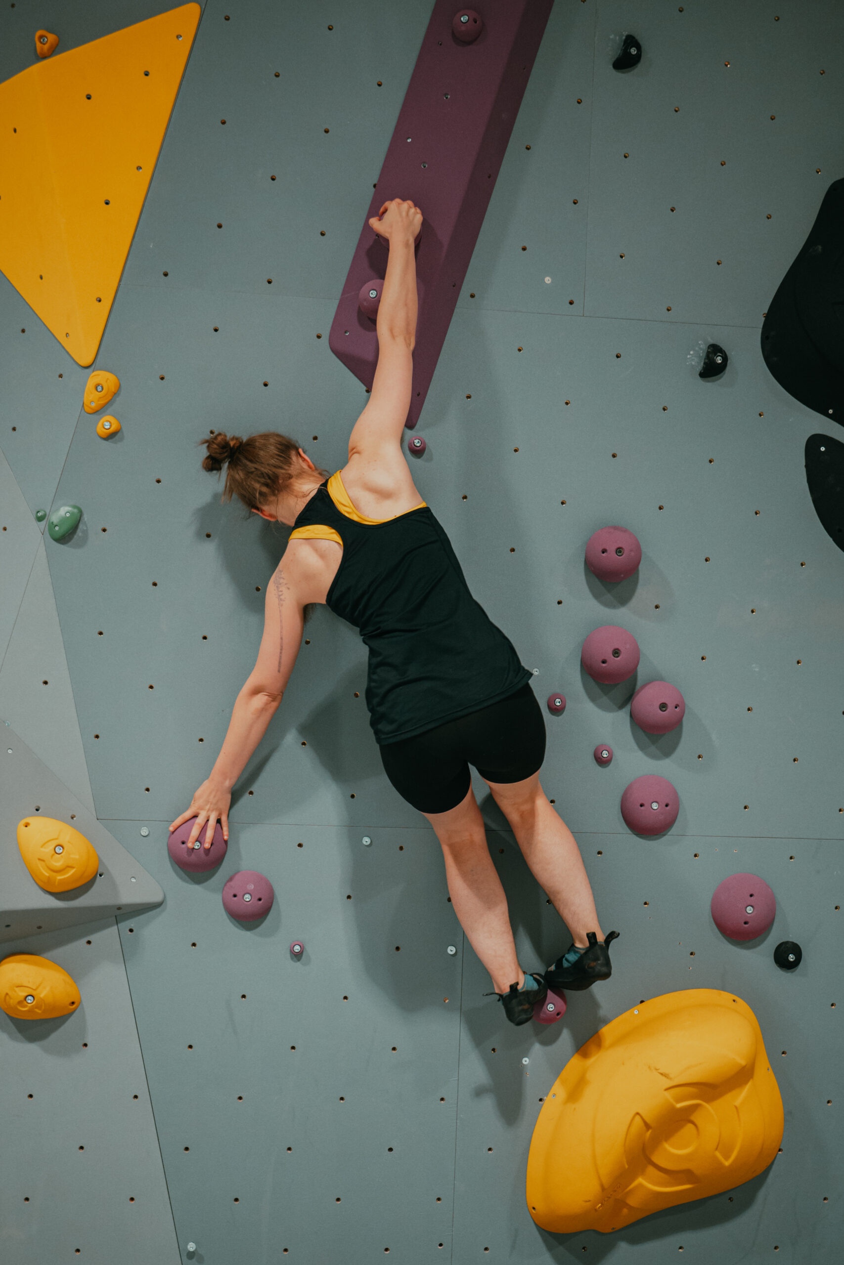 kvinnlig klättrare på bouldervägg